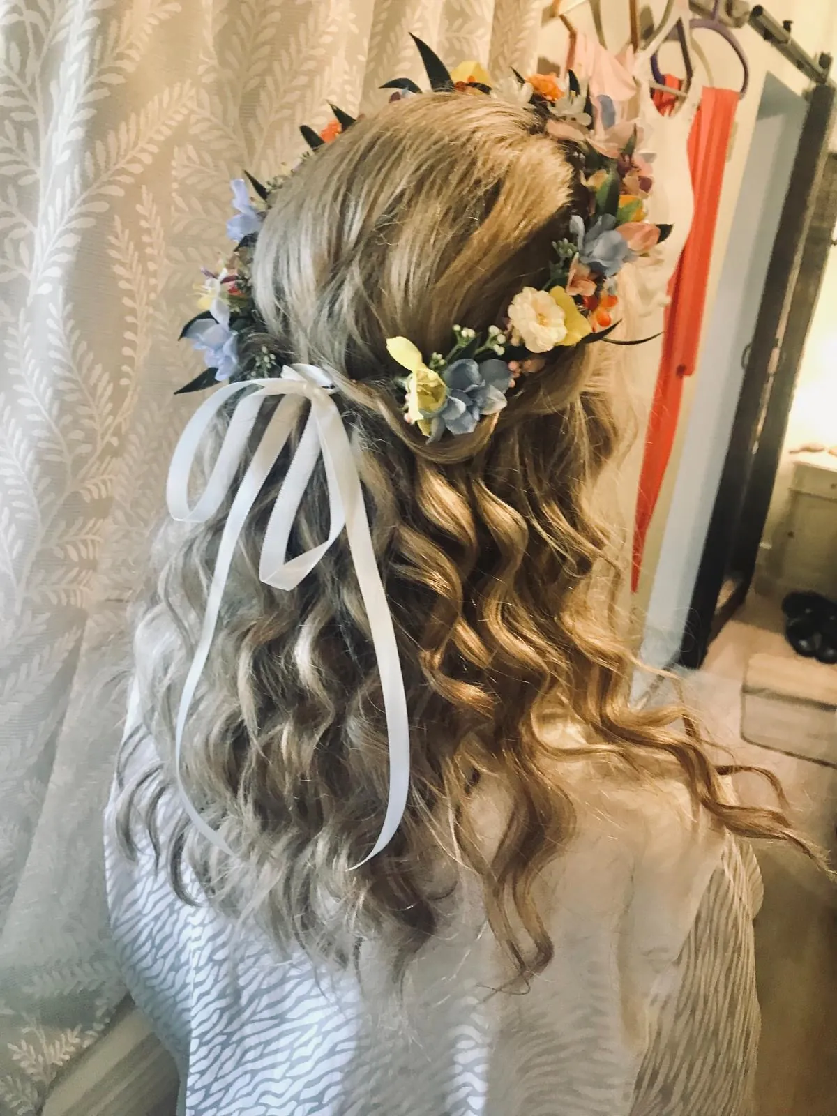 Half-up waves with a wildflower crown tied with ribbon