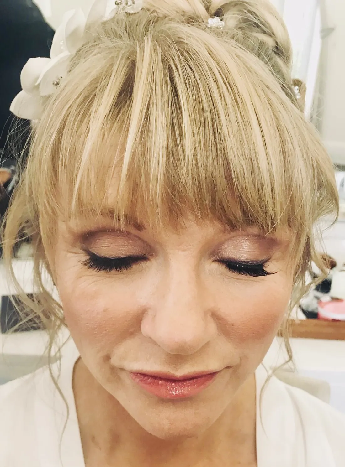 Soft, glowing occasion makeup with a blonde fringe