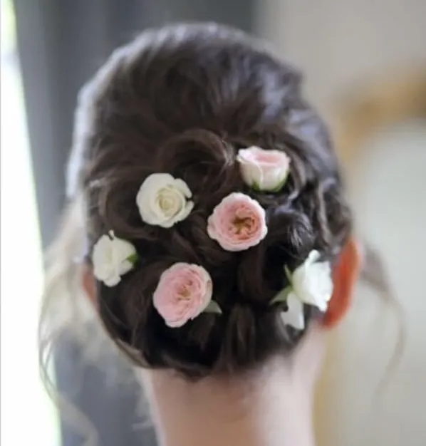 Dark bridal updo finished with pink and white roses